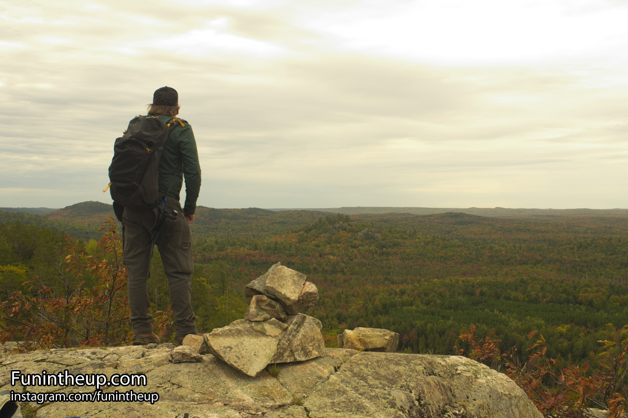Yooper Steve on tallest point on Bald Mountain with rock cairn.